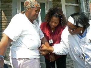 Kimberly Felker and Shirley Camp of SUHI's new diabetes initiative take the waist measure of a North Lawndale resident to determine her risk factor for the disease.