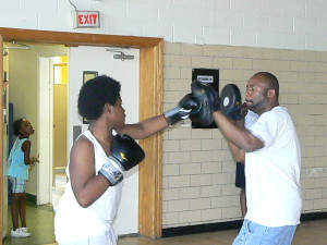 Coach Derek Brown shows the ropes with a youth in his North Lawndale Boxing League. 